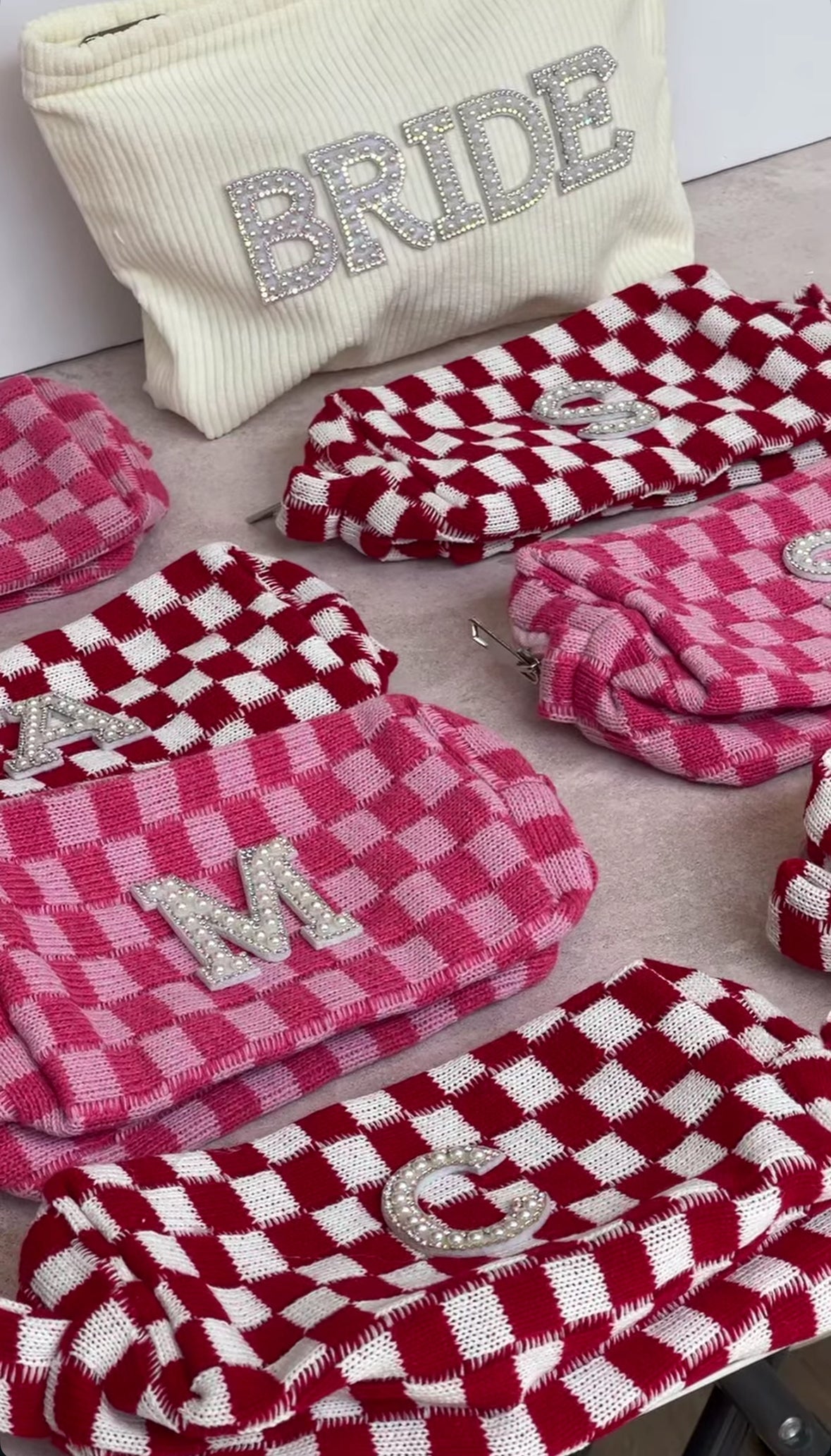 Cosmetiqueras personalizadas de Bride Thru en rojo y rosa, con inicial en perlas, un detalle femenino, útil y encantador para despedidas de soltera o uso diario.