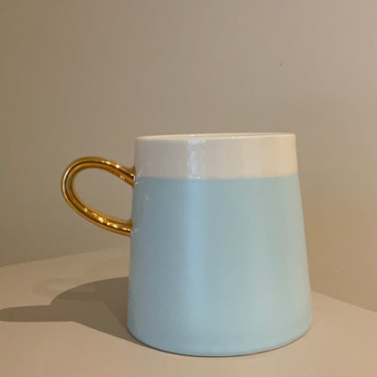 Taza con agarradera dorada