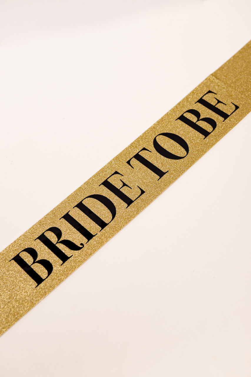 Banda Sash glitter dorado con letra “Bride to Be”  negra para despedida de soltera.