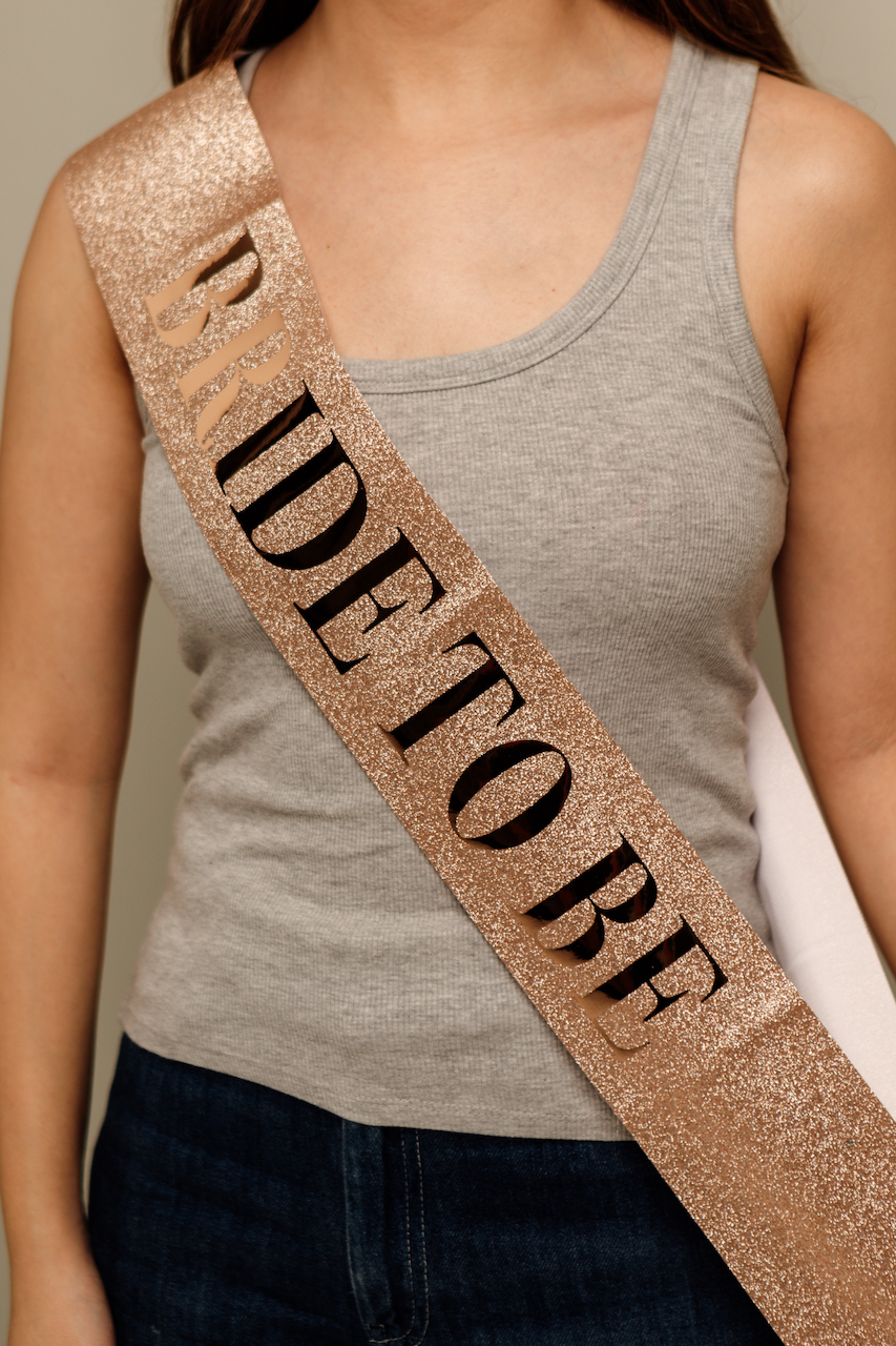 Banda Sash glitter rosegold con letra “Bride to Be”  negra para despedida de soltera.