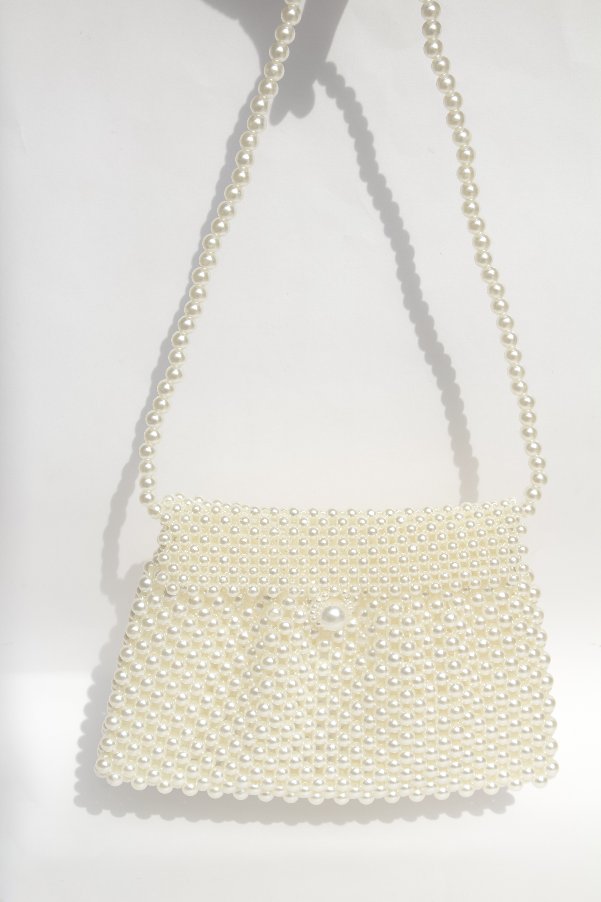 Bolsa blanca hecha con perlas