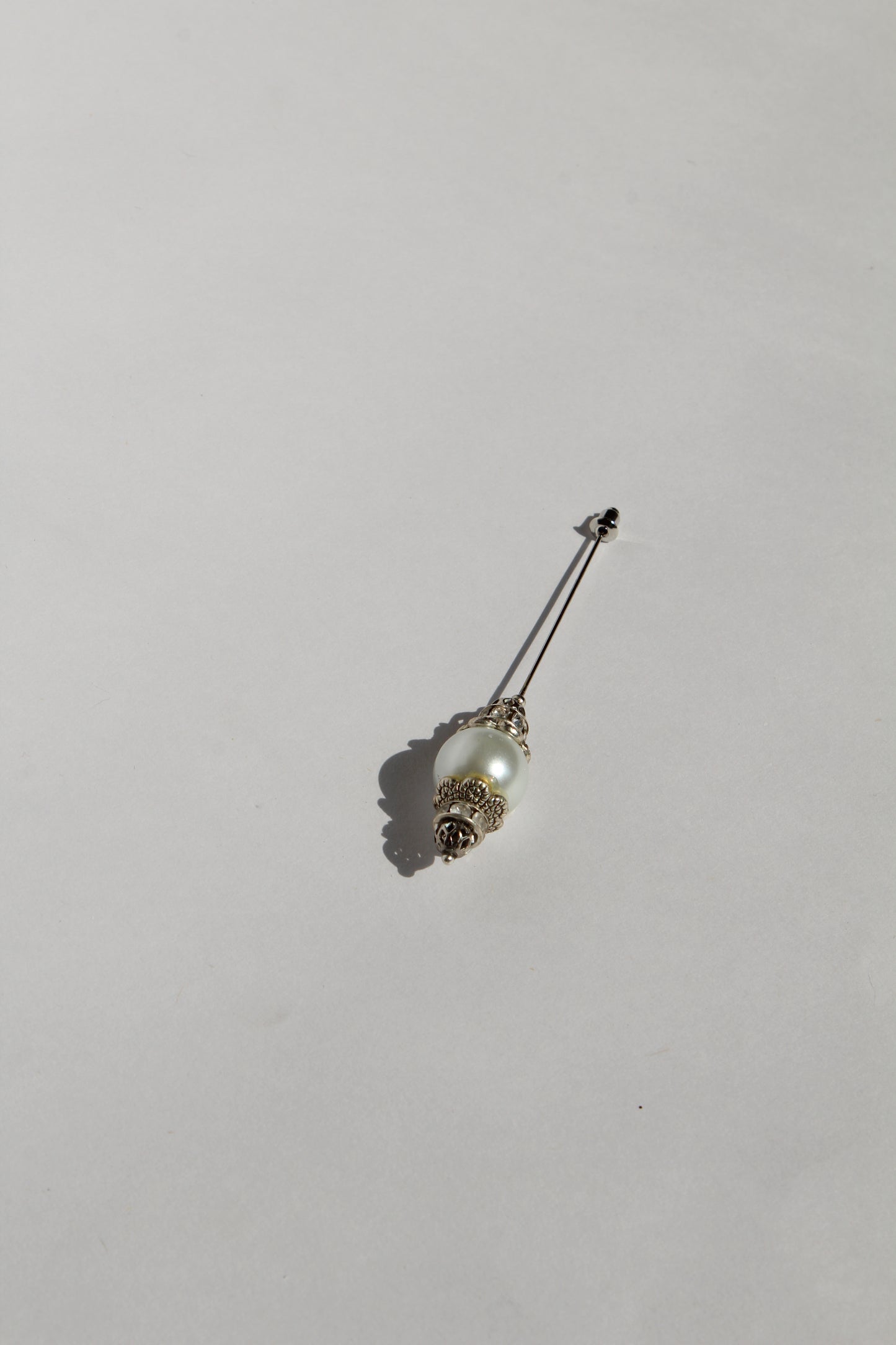 Boutonnière en forma de cetro con una perla