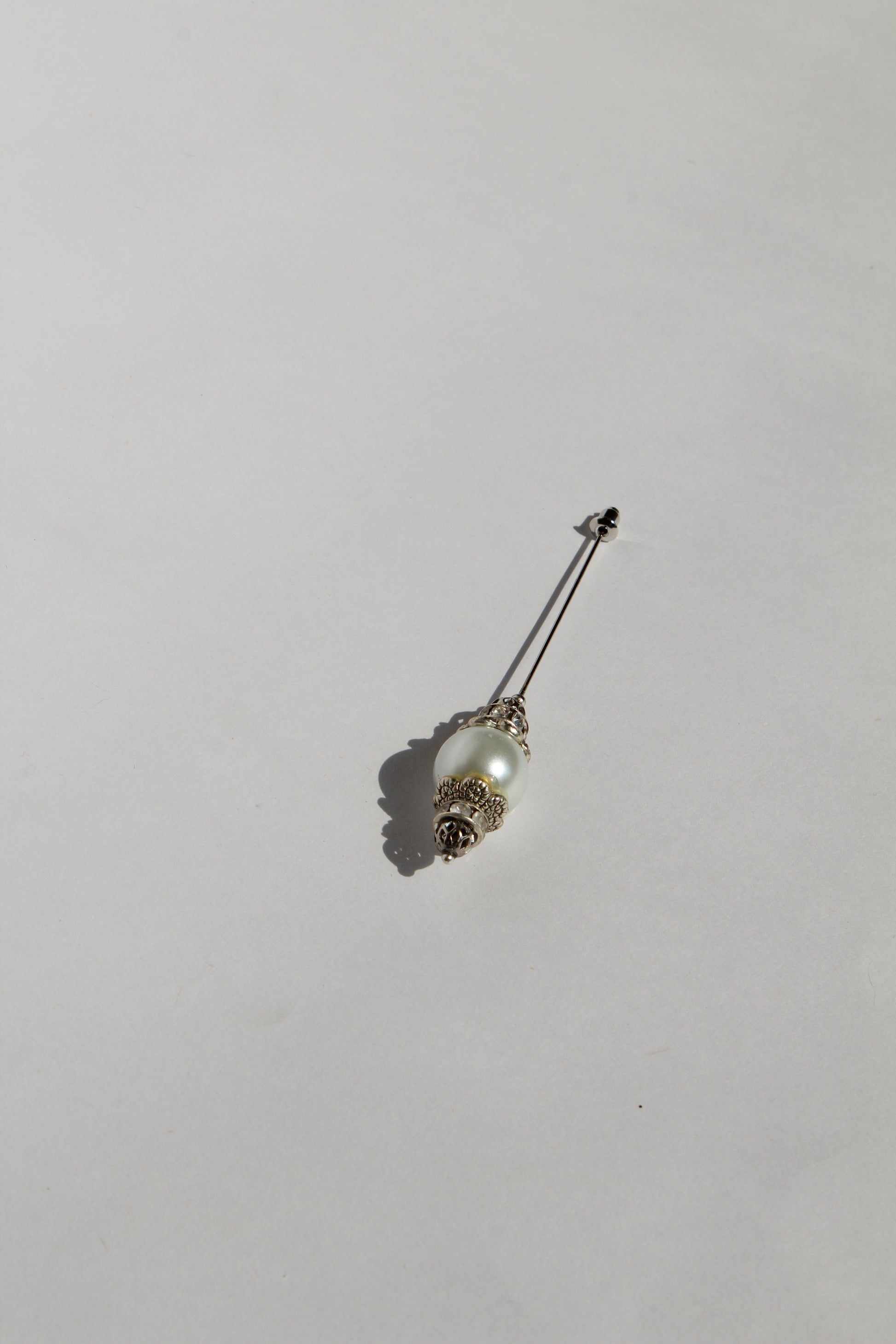 Boutonnière en forma de cetro con una perla