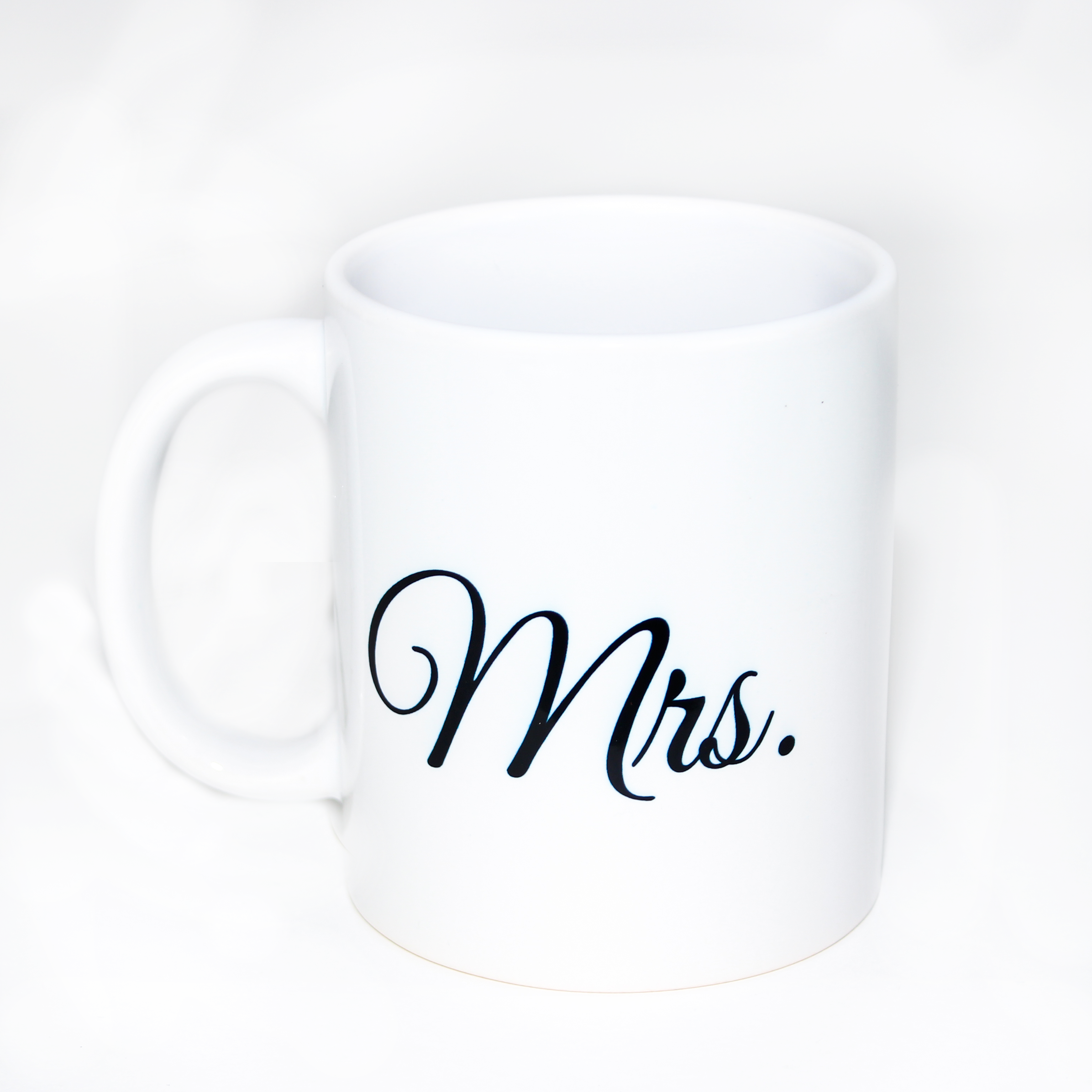 Taza en color blanco con texto "Mrs." en color negro