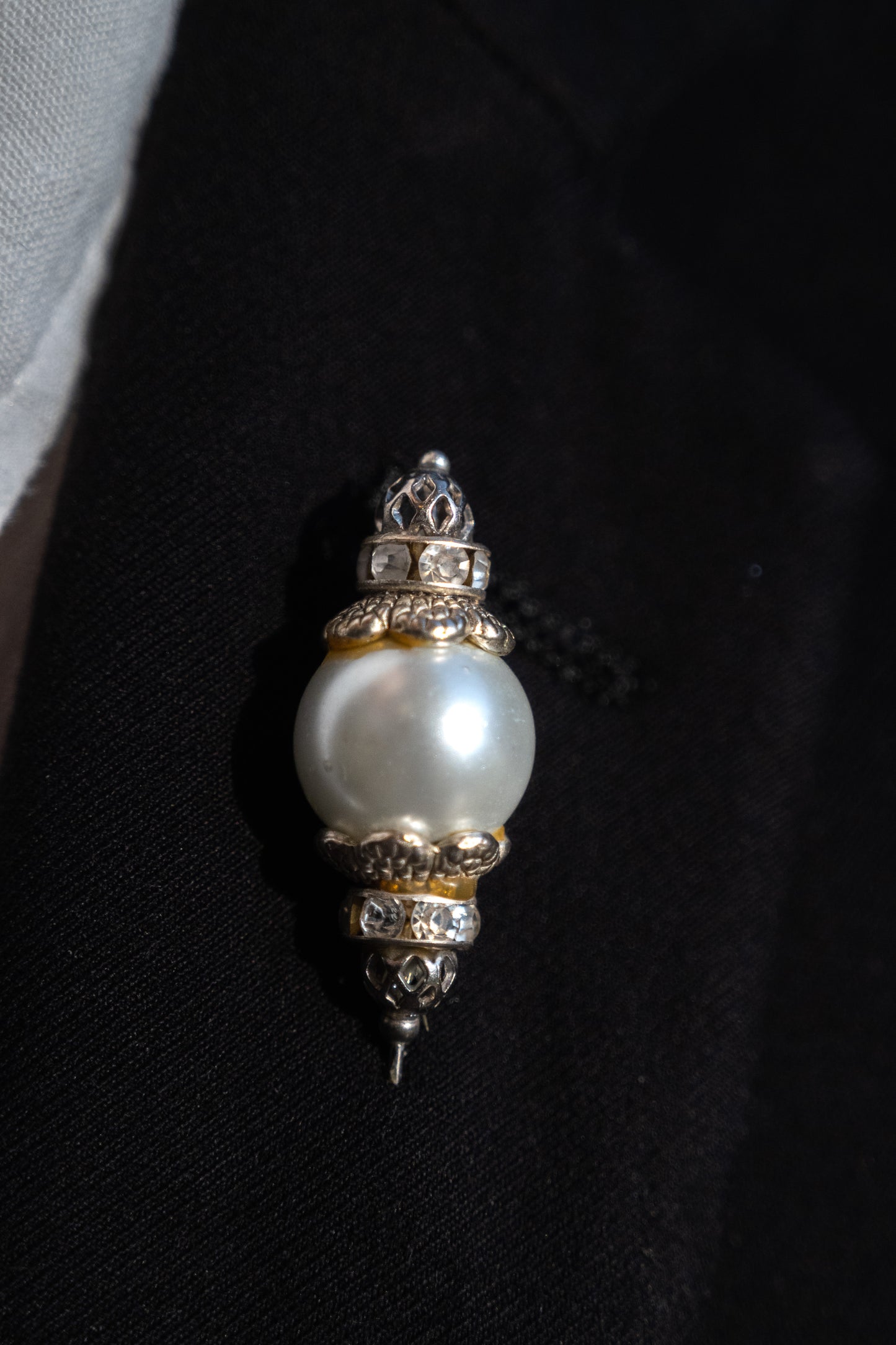 Boutonnière en forma de cetro con una perla