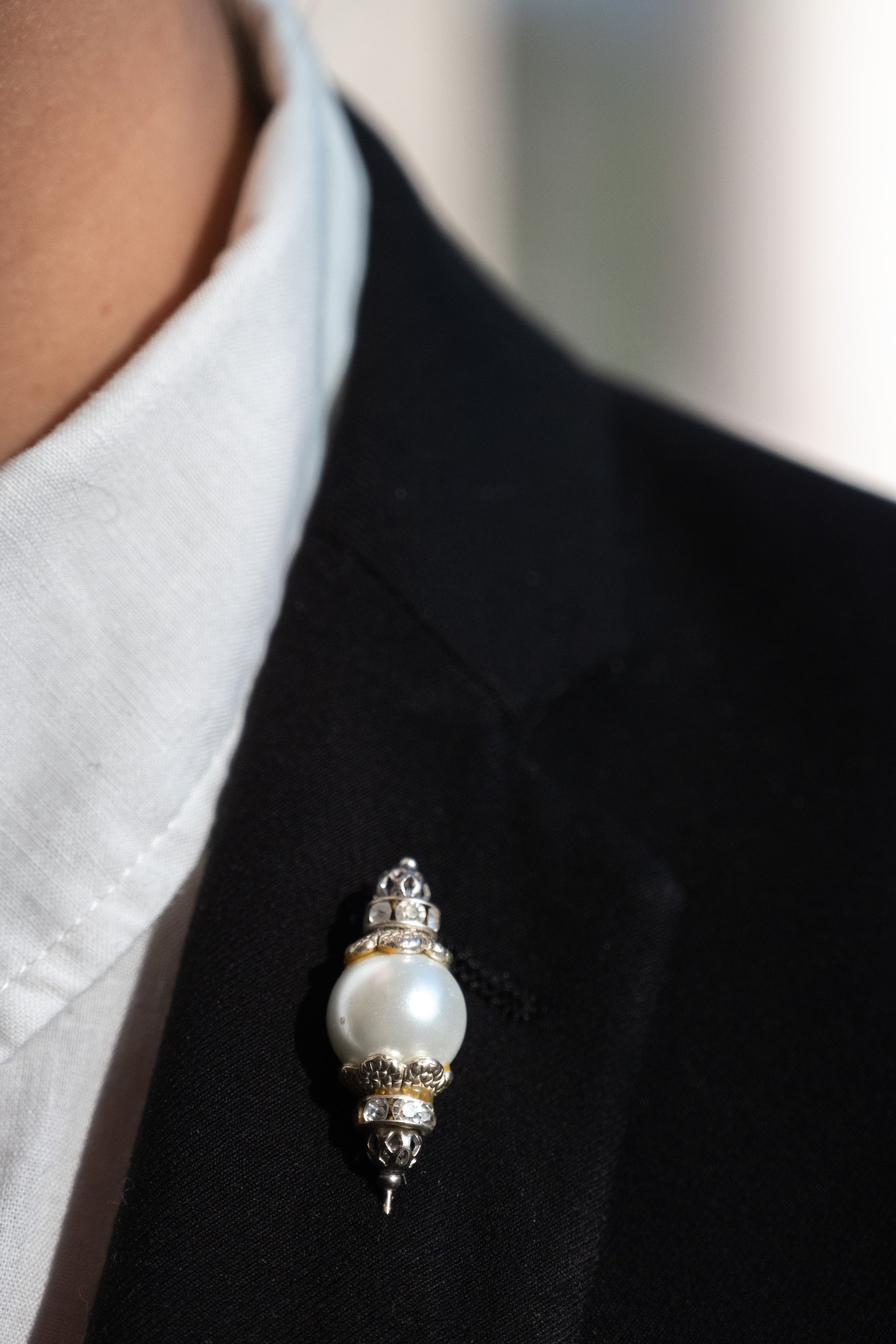 Boutonnière en forma de cetro con una perla