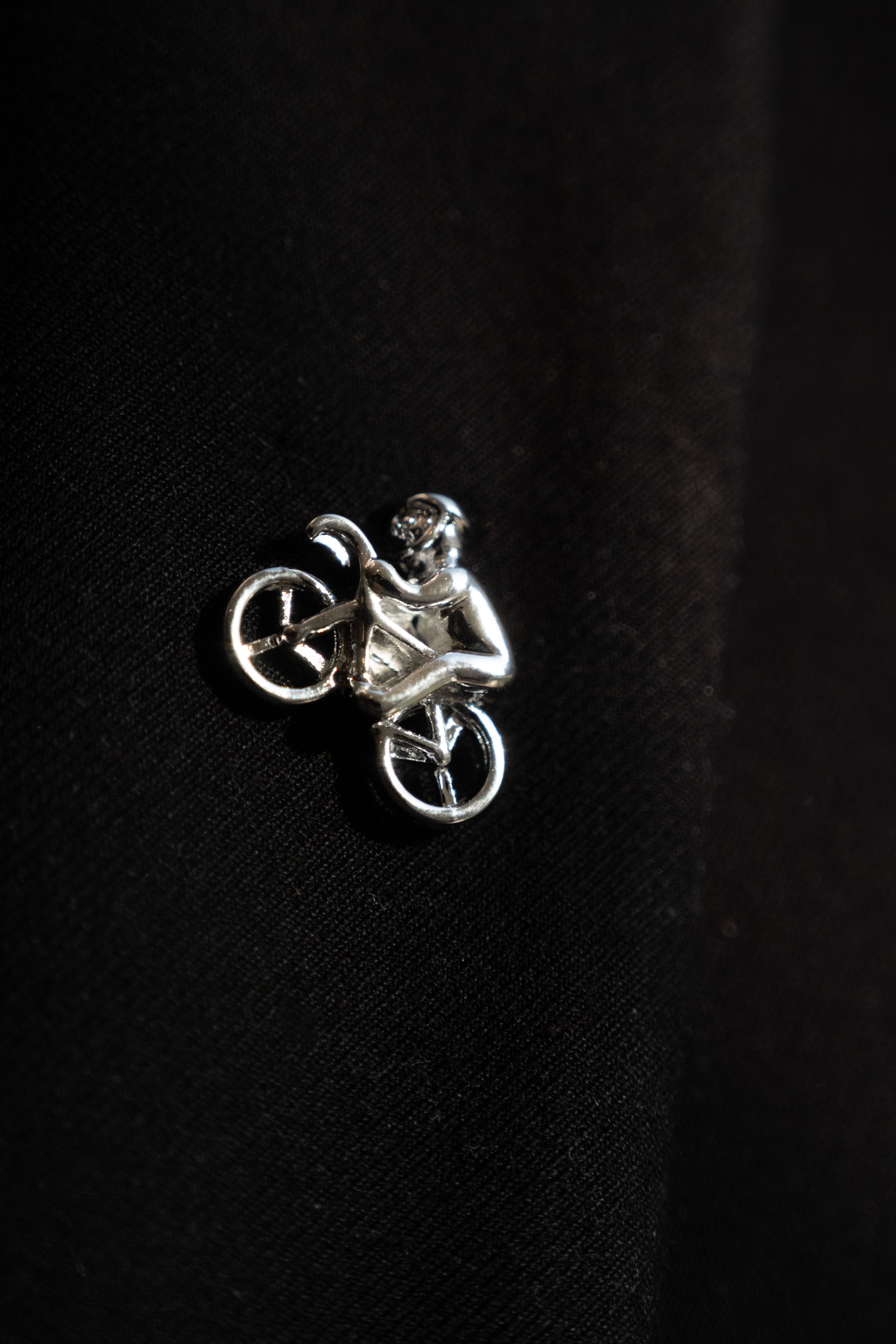 Pin boutonnière en forma de bici con ciclista en color plateado