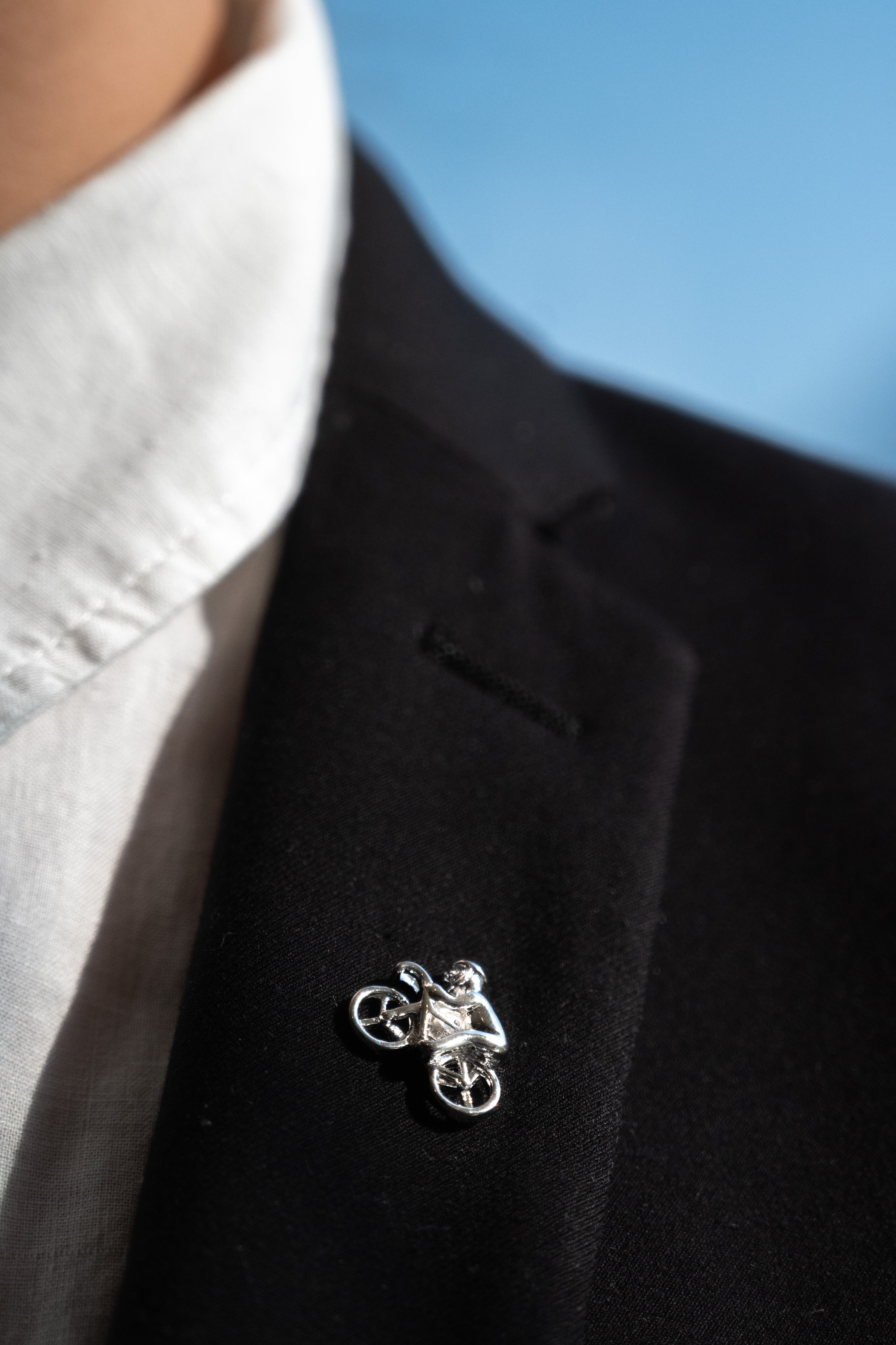 Pin boutonnière en forma de bici con ciclista en color plateado